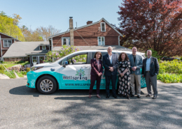 Wellspring van community partners standing in front of the new hybrid passenger van during the ribbon-cutting event in Gloucester, MA.