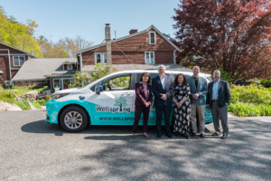 Wellspring van community partners standing in front of the new hybrid passenger van during the ribbon-cutting event in Gloucester, MA.